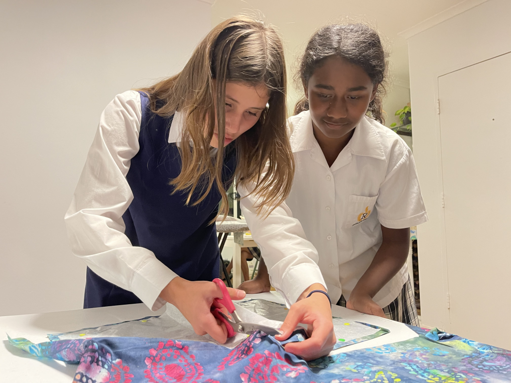 2 course participants cutting fabric